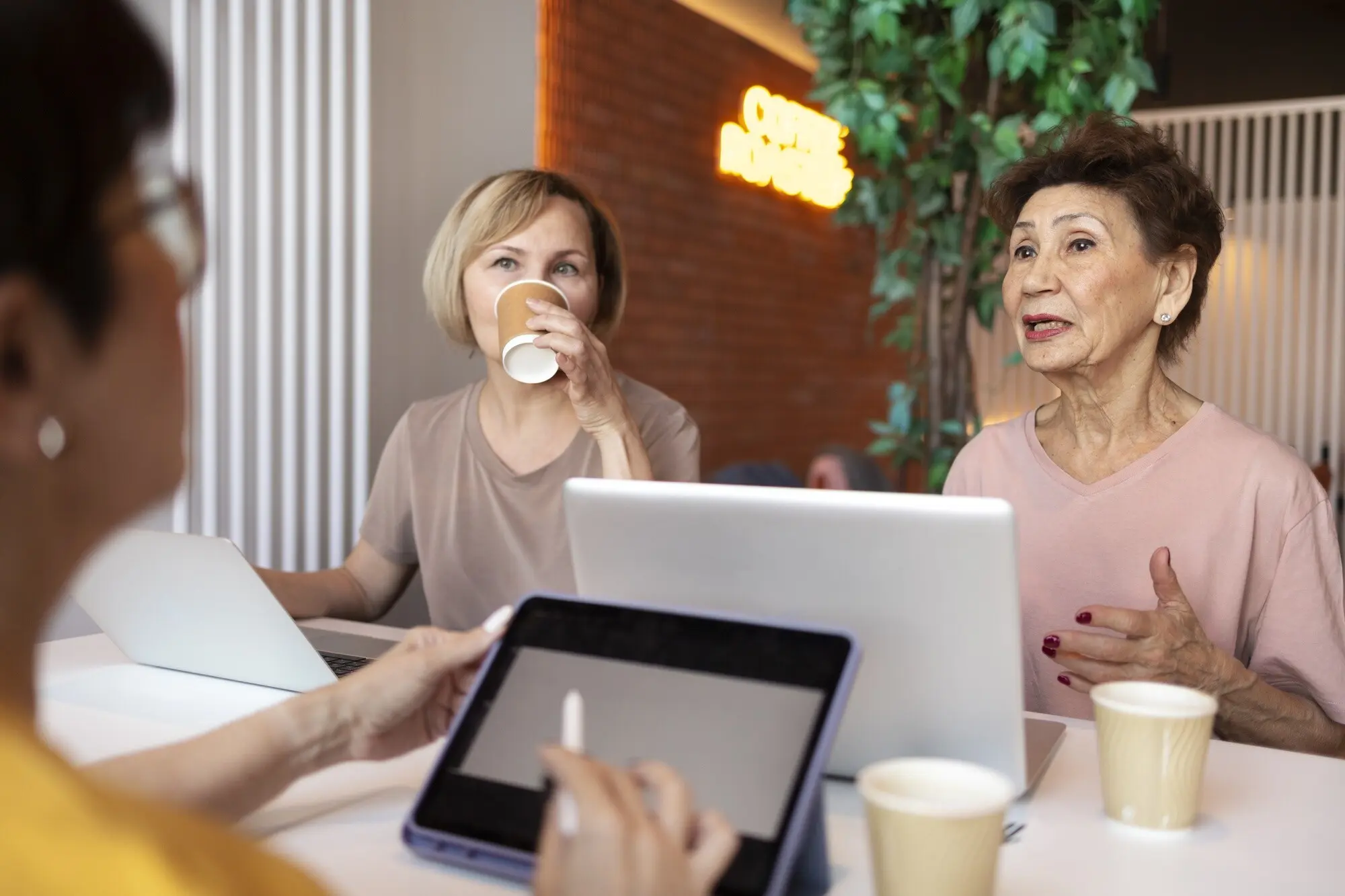 Ältere Frauen verbringen gemeinsam Zeit und arbeiten an einem Laptop.